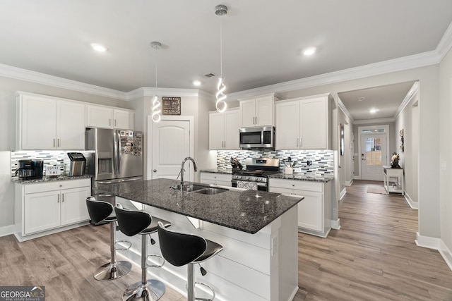 kitchen featuring white cabinetry, sink, an island with sink, and appliances with stainless steel finishes