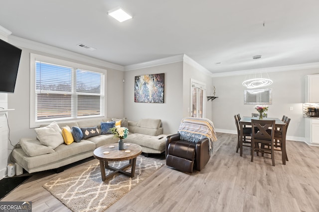 living room featuring ornamental molding and light hardwood / wood-style flooring