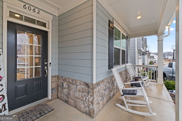 property entrance featuring covered porch and stone siding