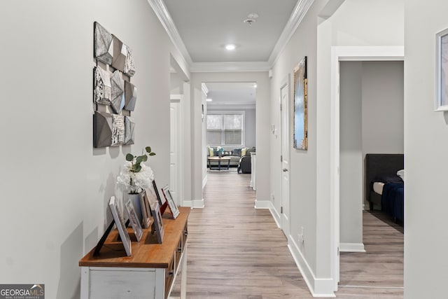 hall with light wood-type flooring, baseboards, crown molding, and recessed lighting