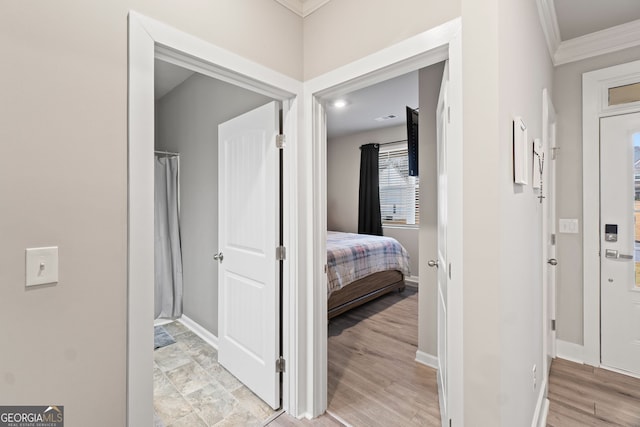 hall featuring crown molding and light hardwood / wood-style floors