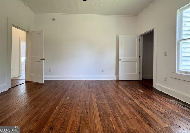 spare room with dark hardwood / wood-style flooring and crown molding