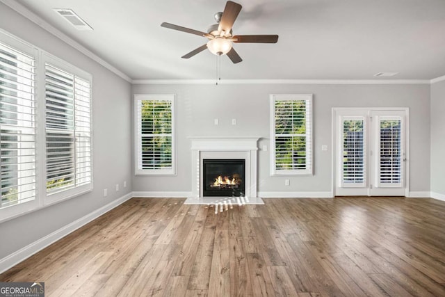 unfurnished living room featuring crown molding, wood-type flooring, and plenty of natural light