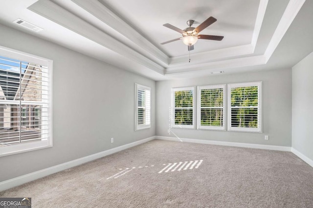 spare room featuring ceiling fan, carpet flooring, and a tray ceiling