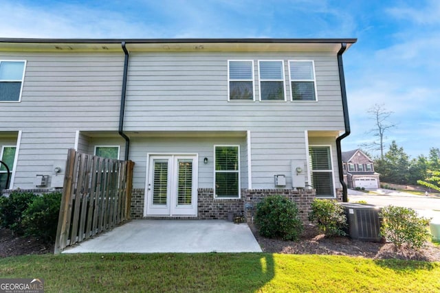 rear view of house featuring a patio area, central air condition unit, and a lawn