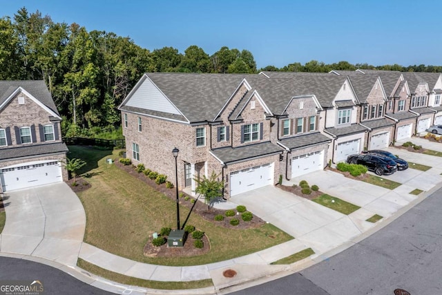 townhome / multi-family property featuring a garage and a front lawn