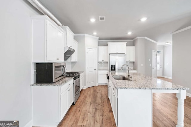 kitchen with sink, an island with sink, white cabinets, and appliances with stainless steel finishes