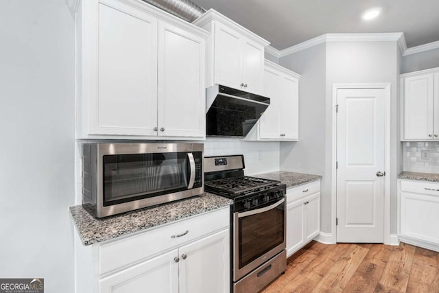 kitchen featuring light stone counters, extractor fan, white cabinets, and appliances with stainless steel finishes