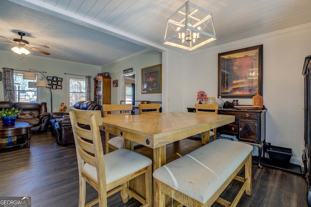 dining space featuring baseboards, dark wood finished floors, crown molding, and ceiling fan with notable chandelier