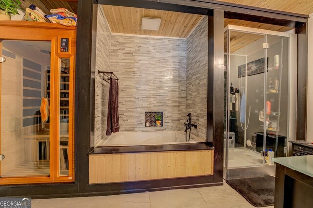 full bathroom with a shower stall, a bath, and tile patterned floors