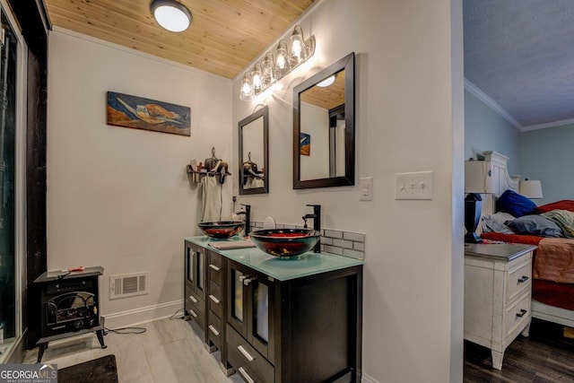 bathroom featuring vanity, crown molding, wooden ceiling, and a wood stove