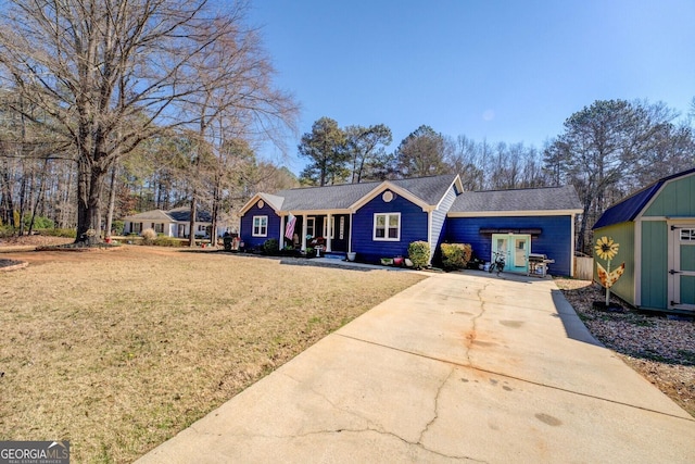ranch-style home with concrete driveway, a front lawn, an outdoor structure, and a storage shed