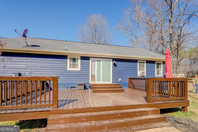 back of house featuring entry steps, roof with shingles, and a deck