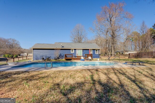 view of pool featuring a fenced in pool, fence, a deck, and a lawn