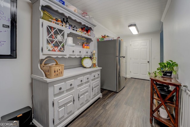 kitchen featuring ornamental molding, stainless steel fridge, dark hardwood / wood-style flooring, and white cabinets