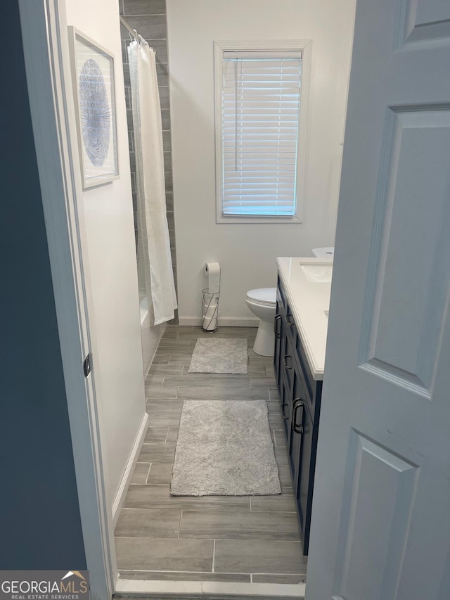 full bathroom with shower / tub combo with curtain, vanity, and toilet