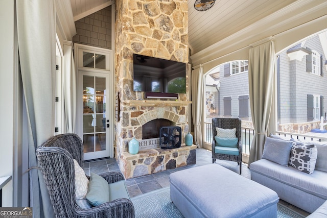 living area featuring wood ceiling, an outdoor stone fireplace, vaulted ceiling, and crown molding