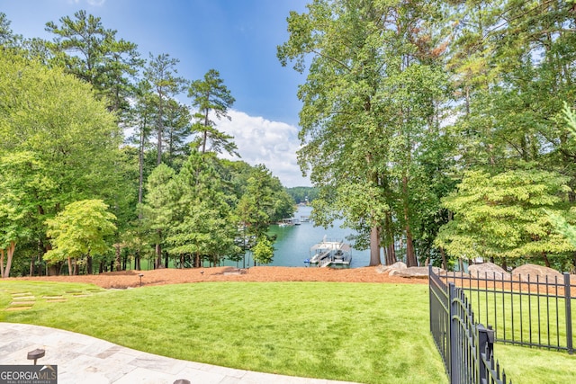 view of yard featuring a water view and fence