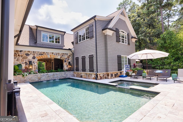 view of pool featuring a pool with connected hot tub, a patio, and fence