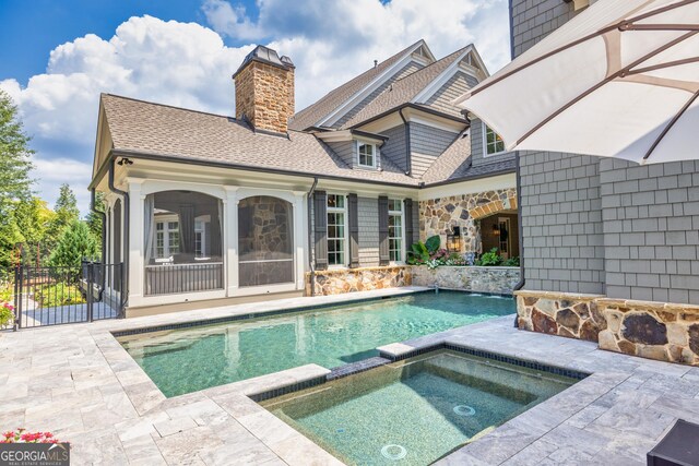 back of property featuring a patio, a sunroom, and a lawn