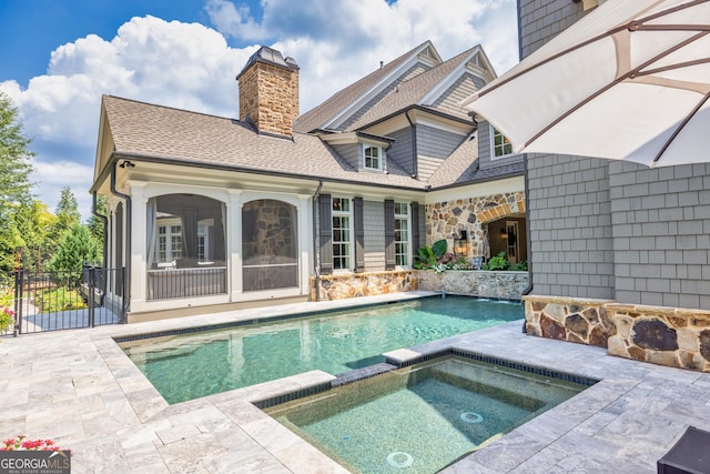 view of pool with a pool with connected hot tub, fence, and a patio