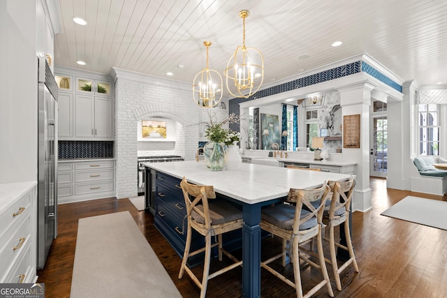 dining space with brick wall, wooden ceiling, a notable chandelier, and dark hardwood / wood-style flooring