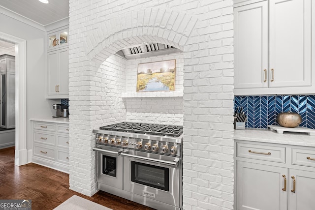 kitchen with dark wood-type flooring, white cabinetry, double oven range, decorative backsplash, and glass insert cabinets