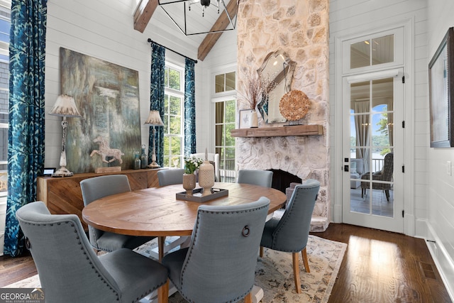 dining room with beamed ceiling, dark hardwood / wood-style flooring, high vaulted ceiling, and wood walls