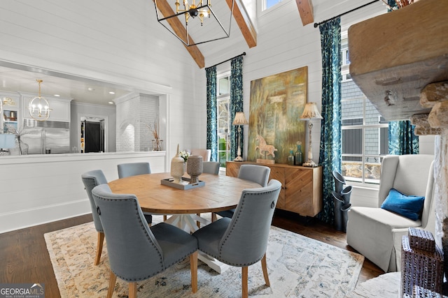 dining room featuring wood finished floors, a healthy amount of sunlight, beamed ceiling, and an inviting chandelier