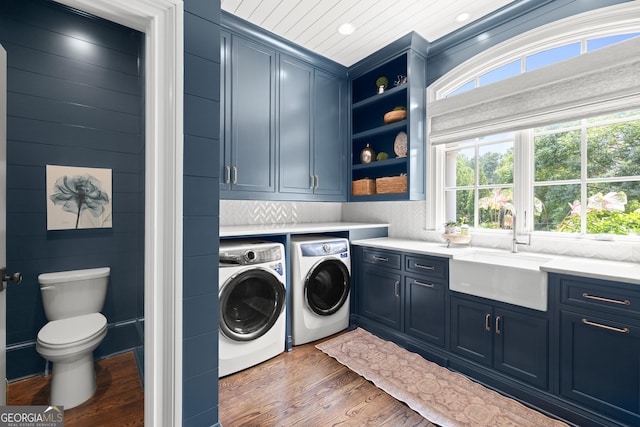 laundry area featuring sink, dark hardwood / wood-style floors, cabinets, and washer and dryer