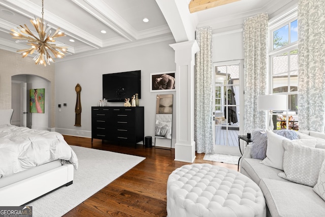 bedroom with ornate columns, beam ceiling, ornamental molding, dark wood-type flooring, and an inviting chandelier