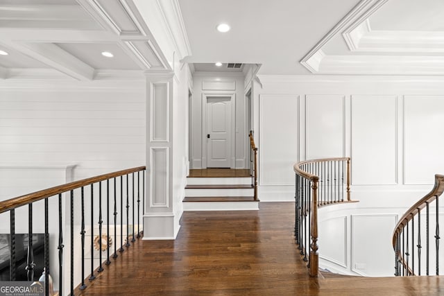 corridor featuring dark wood-type flooring, beamed ceiling, ornamental molding, and ornate columns