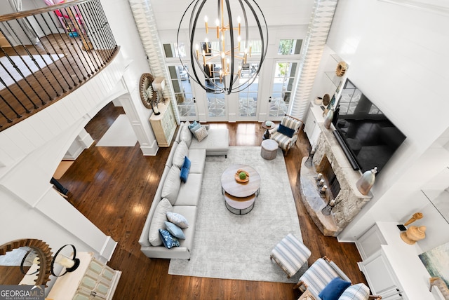 living room featuring an inviting chandelier, a towering ceiling, and dark hardwood / wood-style flooring