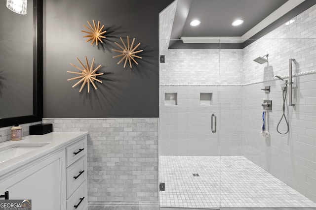 bathroom featuring recessed lighting, vanity, tile walls, wainscoting, and a shower stall