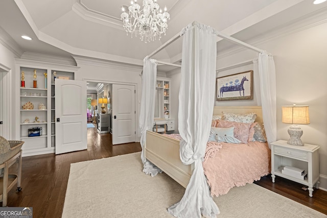 bedroom featuring crown molding, dark wood-type flooring, a raised ceiling, and a chandelier