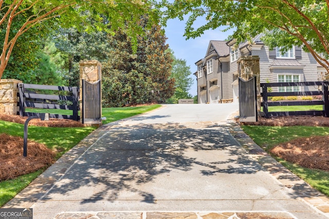 view of road with concrete driveway, a gated entry, and a gate