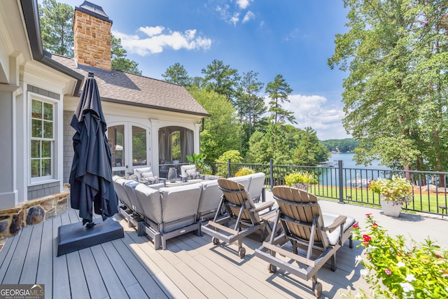 deck with outdoor lounge area and a water view