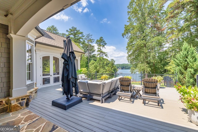 wooden deck with a water view and an outdoor living space