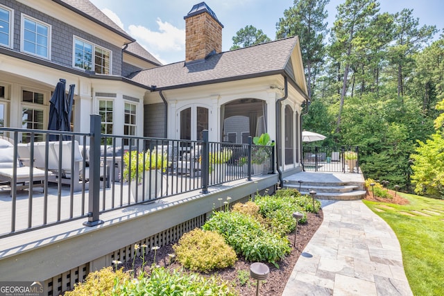 exterior space with french doors, roof with shingles, and a chimney