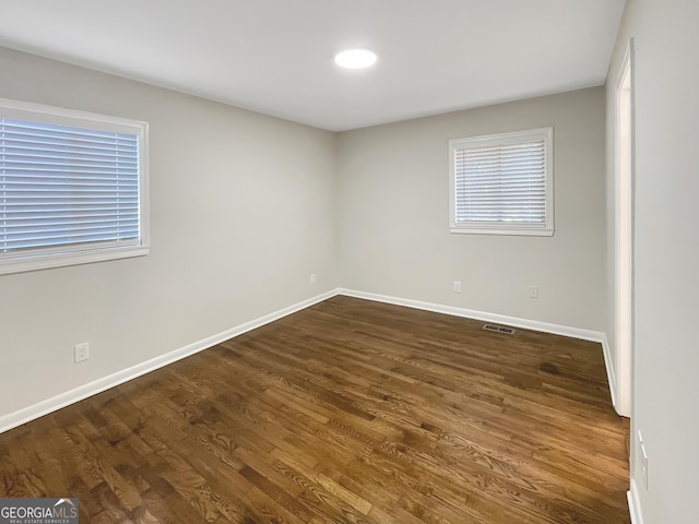 unfurnished room with dark wood-type flooring