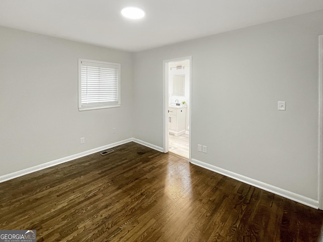 spare room featuring dark wood-type flooring