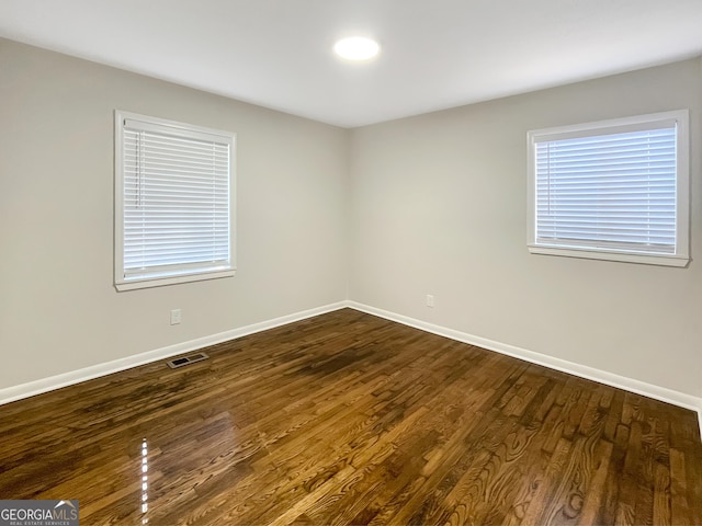 unfurnished room with dark hardwood / wood-style flooring