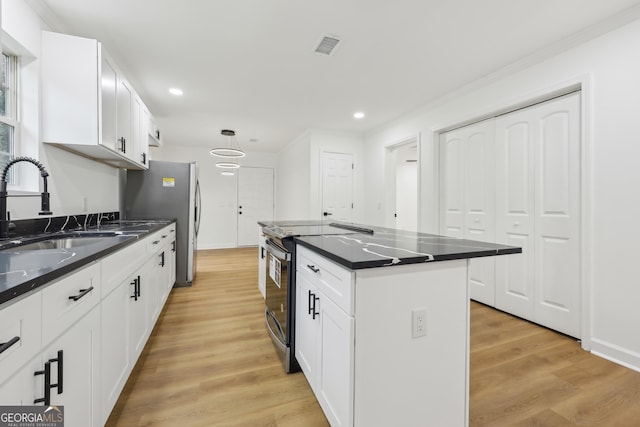 kitchen with black / electric stove, a sink, white cabinetry, light wood-style floors, and a center island