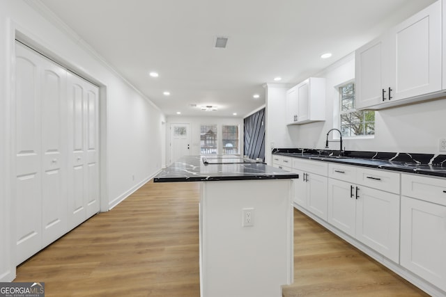 kitchen with visible vents, light wood-style flooring, a center island, white cabinetry, and recessed lighting