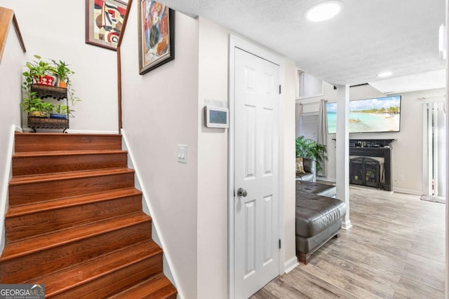 stairs featuring hardwood / wood-style flooring and a textured ceiling