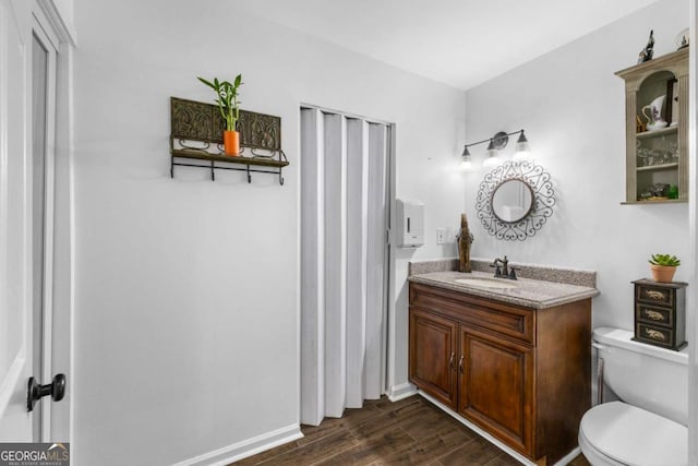 bathroom featuring vanity, toilet, and hardwood / wood-style floors