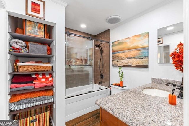 bathroom with wood-type flooring, combined bath / shower with glass door, and vanity