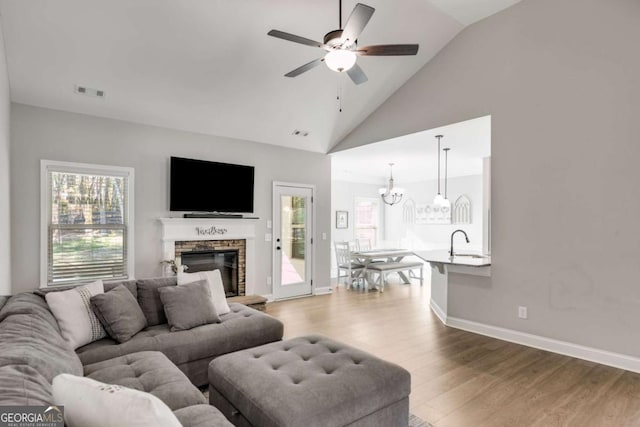 living room featuring sink, a fireplace, hardwood / wood-style floors, and a healthy amount of sunlight