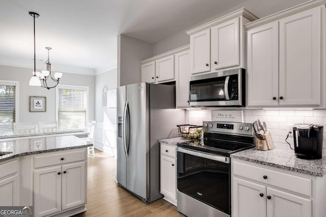 kitchen with white cabinetry, stainless steel appliances, light stone countertops, and pendant lighting