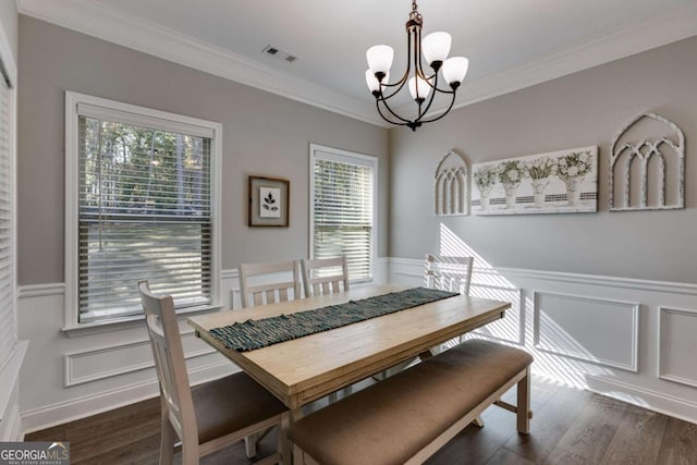 dining space featuring crown molding, dark hardwood / wood-style floors, and a notable chandelier